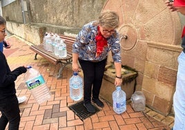 Una mujer recoge agua de una de las fuentes de Álora.