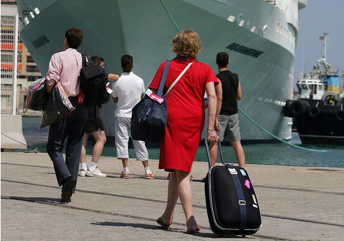 Una crucerista se dirige hacia el barco en el que disfrutará de sus vacaciones.