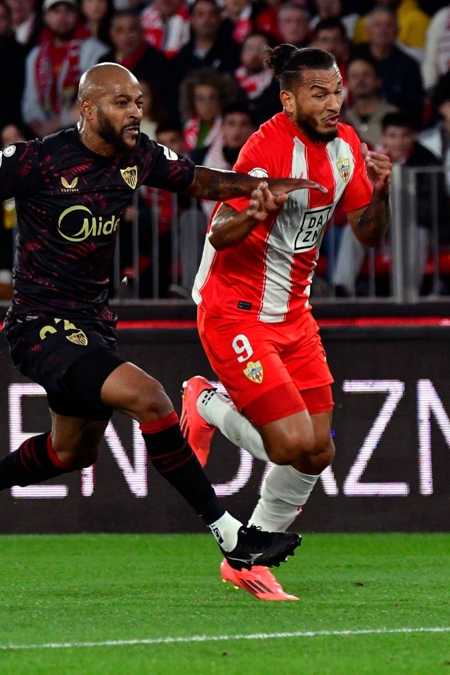 Luis Suárez busca superar en carrera a Marcos, defensa del Sevilla, en el duelo de Copa.
