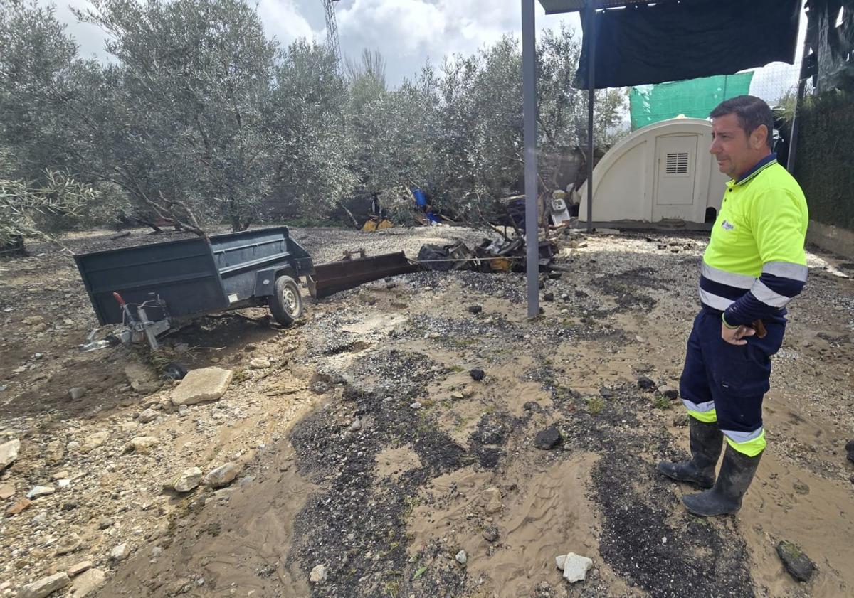 Imagen principal - Trabajadores en el polideportivo, Juan Manuel García, limpiando con su máquina el barro y su padre, en la parcela de su hijo.