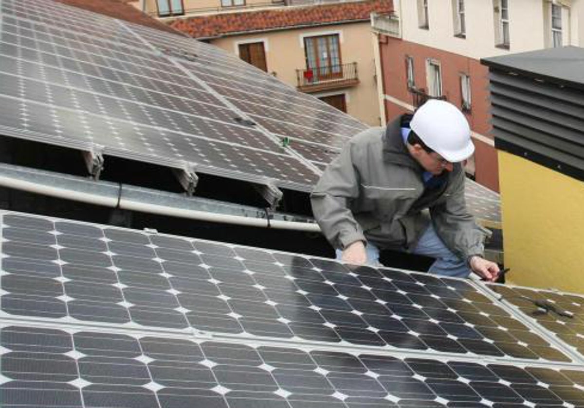 Un operario instala una placa fotovoltaica.