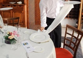 Preparación de una mesa para recibir a comensales.