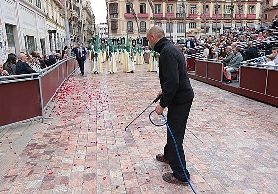 Un operario extiende el líquido anticera al paso de la Cofradía de la Pollinica.