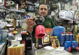 Imagen de archivo de un vendedor despachando un camping gas en una ferretería.