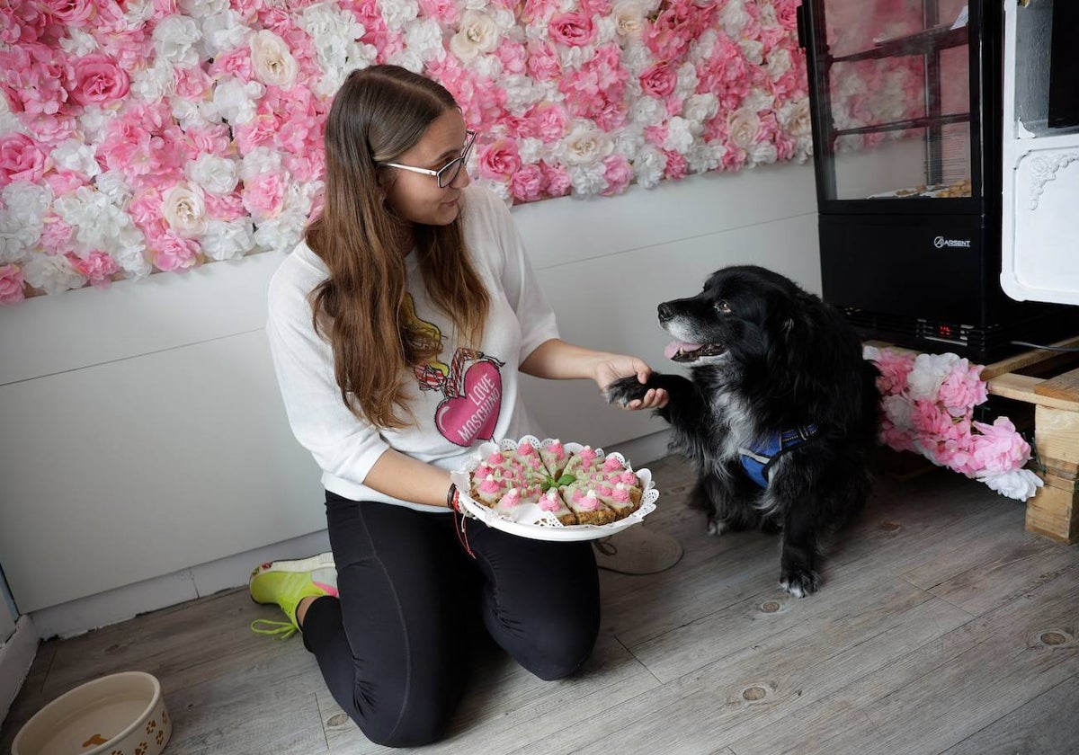 Simona junto a su perro Maco en el interior de la tienda.