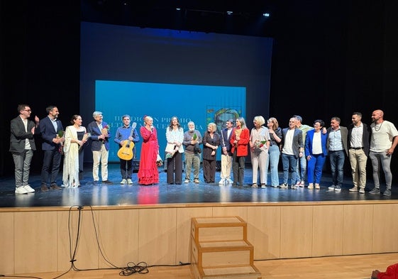 Foto de familia con los premiados y los dirigentes socialistas, en el escenario del teatro de Torrox.