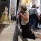 Una mujer reza ante la capilla donde se encuentran la Esperanza y el Cachorro.