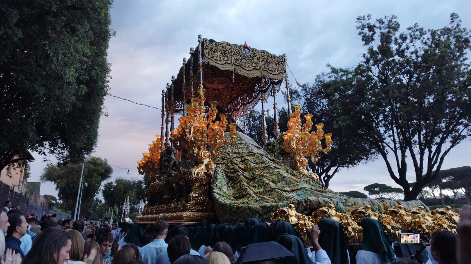 Ante la lluvia, la cofradía tuvo que cubrir el manto de la Virgen con uno de plástico serigrafiado con el futuro diseño del manto