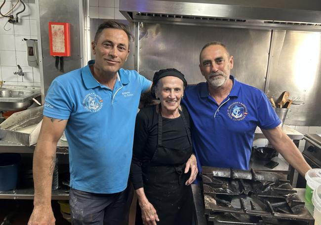 Juana Rodríguez, con sus dos hijos, Nono y César, en la cocina del histórico chiringuito Morata.