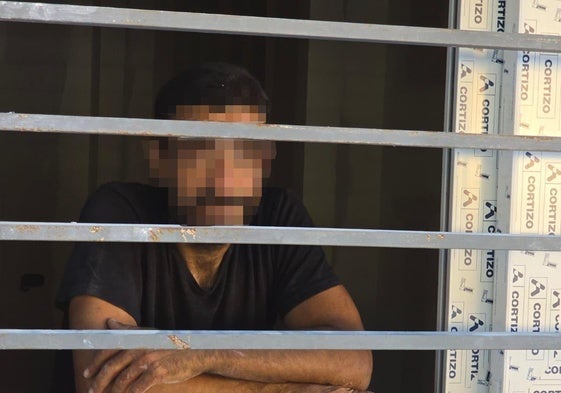 El detenido, mientras esperaba a los bomberos en el piso en el que fue sorprendido.