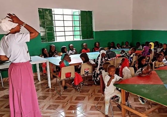 La maestra Amie junto a niños y niñas en clases de verano de la Escuela Infantil Blas Infante en Douasu (Gambia).