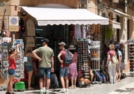 Turistas buscan un recuerdo de su paso por Málaga.
