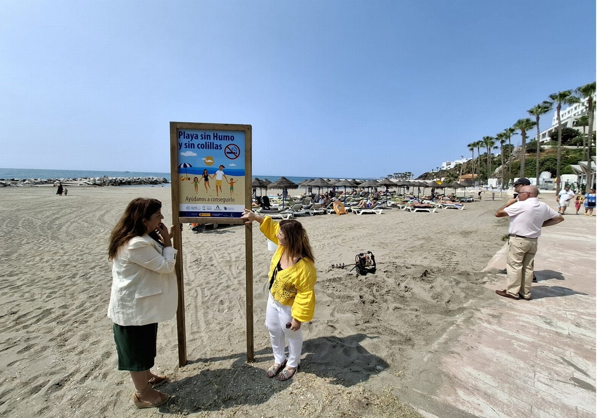 A la izquierda, la concejal Presi Aguilera observa junto a una miembro de su equipo uno de los carteles que van a ser instalados en Playa Bonita.