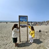 A la izquierda, la concejal Presi Aguilera observa junto a una miembro de su equipo uno de los carteles que van a ser instalados en Playa Bonita.