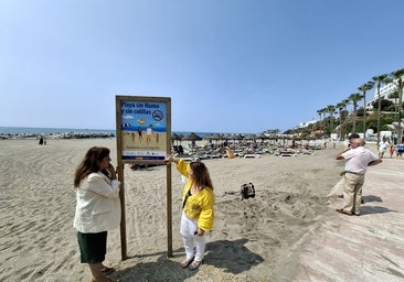 A la izquierda, la concejal Presi Aguilera observa junto a una miembro de su equipo uno de los carteles que van a ser instalados en Playa Bonita.