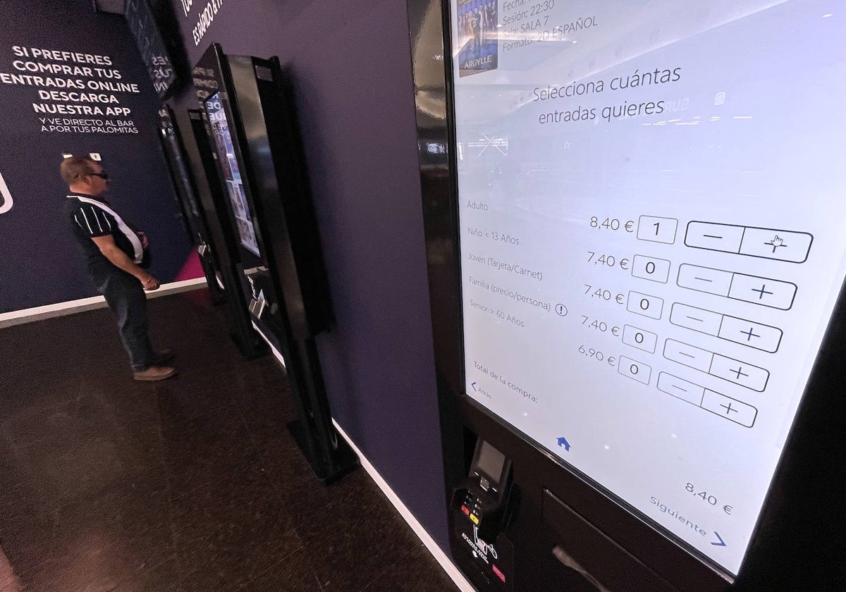 Una espectador compra una entrada en uno de las taquillas interactivas en la entrada a los cines de Vialia.