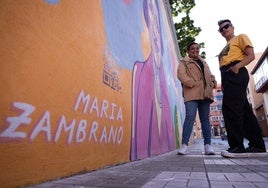 Daniela Miazzo, con la directora del Miguel de Cervantes, Ana Muñoz, y el mural de María Zambrano.