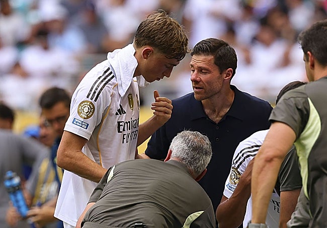 Xabi Alonso dialoga con Huijsen en una pausa de hidratación en el partido.