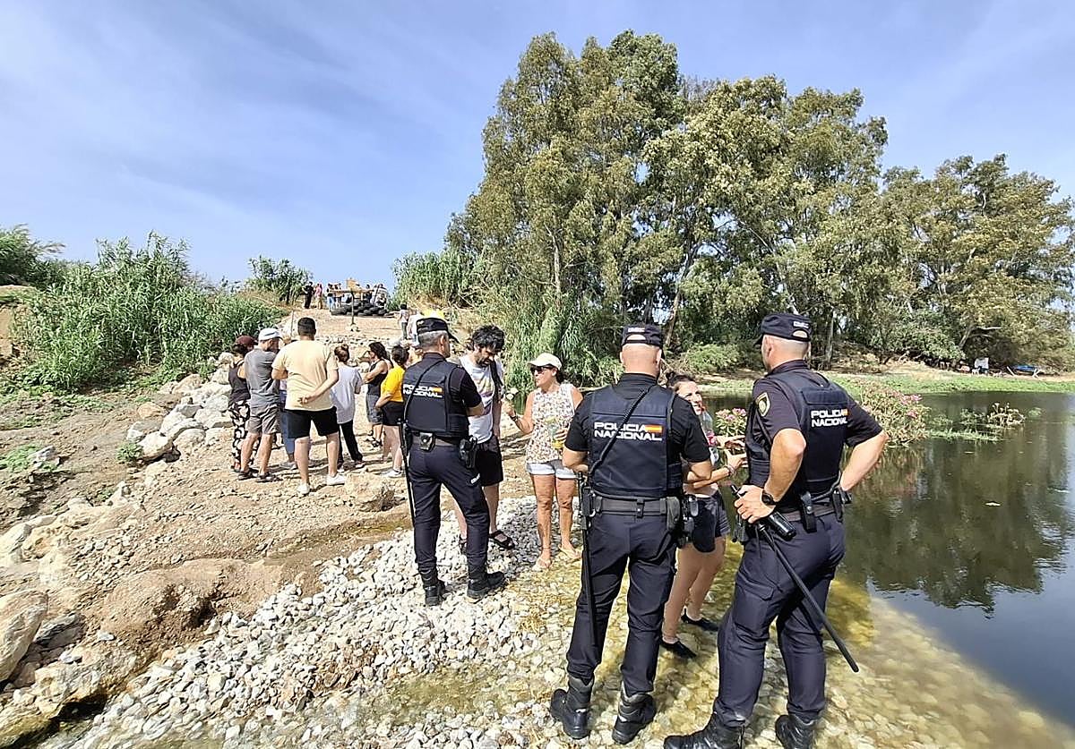 Policías y vecinos, apostado junto al río.