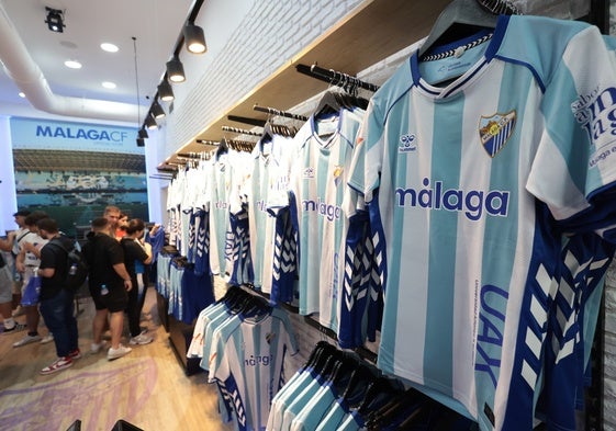 Imagen de la nueva camiseta del Málaga para la temporada 2025-26, en la tienda de Calle Larios.
