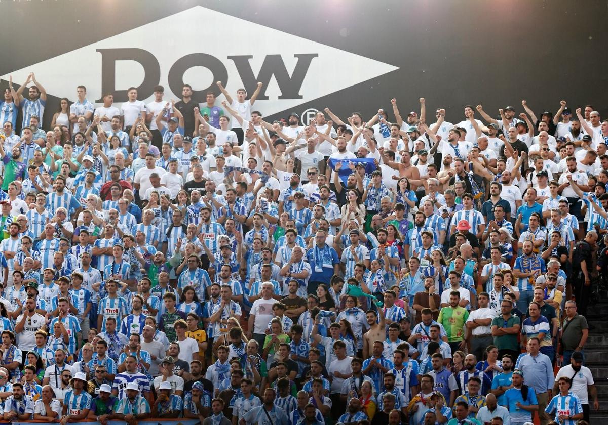 Los aficionados del Málaga en la grada visitante del Nou Estadi, animando al conjunto blanquiazul.