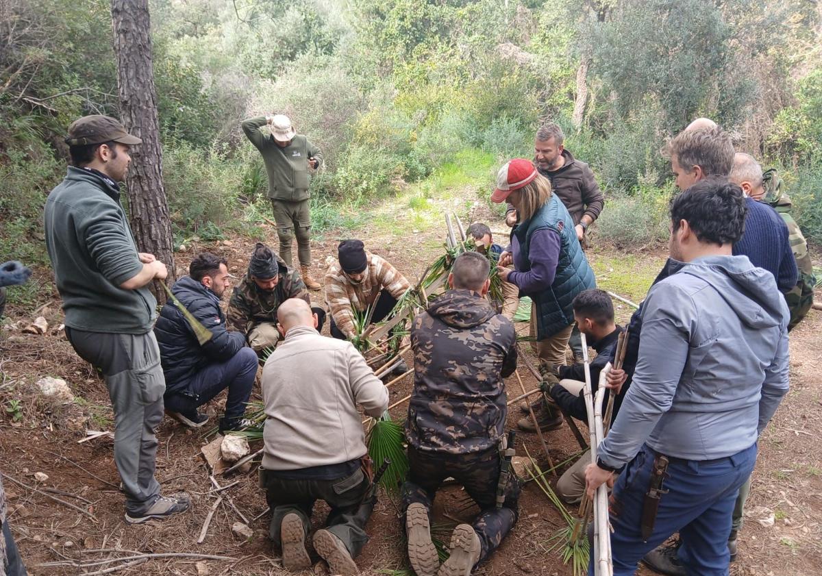 Imagen principal - Alumnos haciendo el refugio donde dormirán esa noche. La topografía es un elemento importante en la orientación. Pepe Ogalla observa como uno de sus alumnos logra hacer fuego