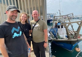 De izquierda a derecha, David León y Bárbara Conejero, de la Asociación Hombre y Territorio y el pescador Eduardo Peña. Al fondo, el barco 'Jaime y Sara'.