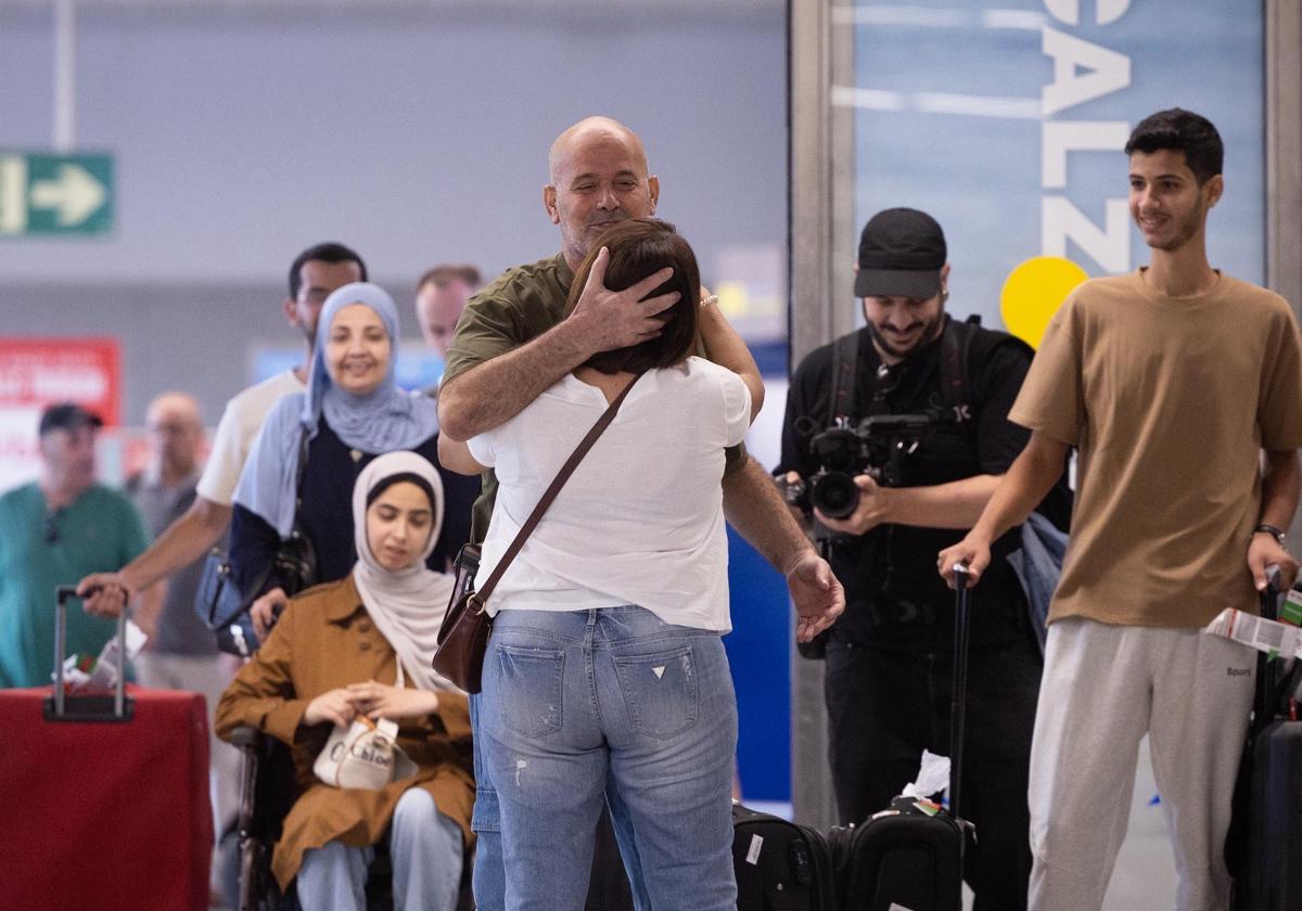 Kayed es abrazado por su cuñada, Soad, en la terminal de llegadas de Málaga ante la mirada de su esposa y sus hijos.