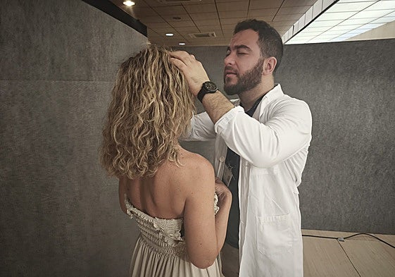 Un dermatólogo atiende a una paciente.