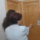 Imagen de archivo de una vecina señalando la puerta de la vivienda de la víctima, precintada por la Policía.