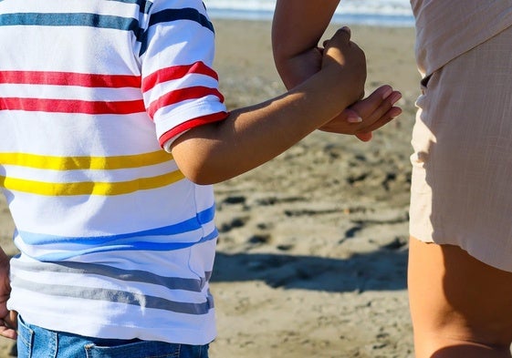 Imagen del pequeño junto a su madre en la playa de El Dedo.