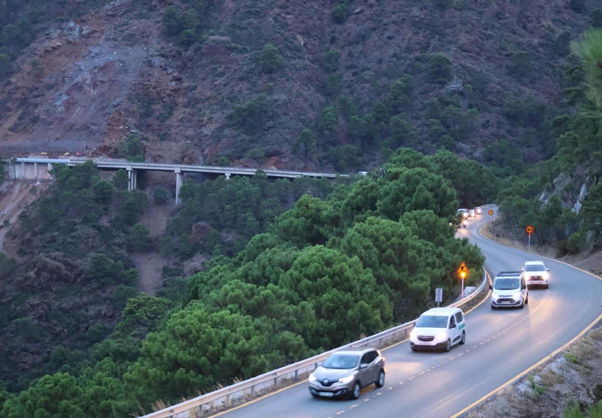 Los primeros coches pasan por la carretera ya abierta.