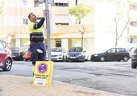 Un operario coloca señalización que avisa de trabajos de asfaltado en Torremolinos.