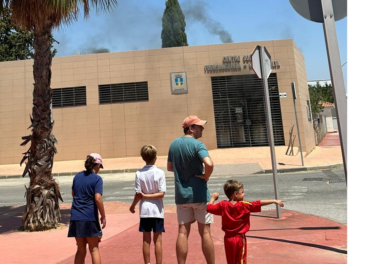 Un grupo observa el humo en el centro social.