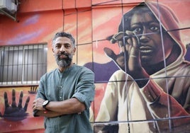 Ahmed Khalifa posa ante uno de los murales que luce la fachada del local que la asociación que preside tiene en Málaga.