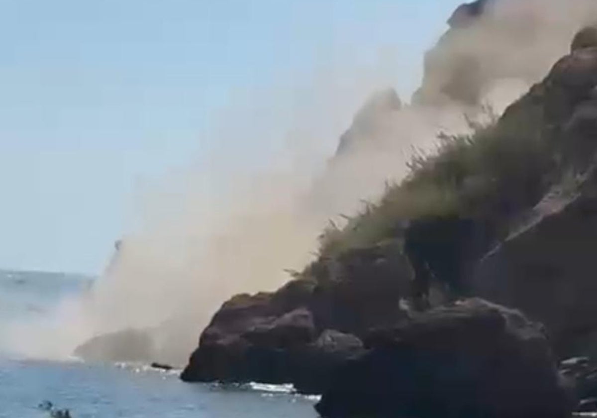 Imagen de la enorme polvareda generada por el desprendimiento de rocas y tierra, en la tarde de este domingo junto a la playa de Maro.