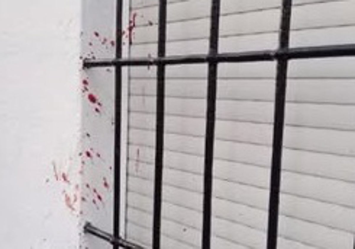 Restos de sangre en la pared de una vivienda en la calle en la que ocurrieron los hechos.