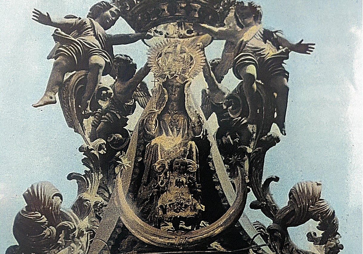 La Virgen de la Victoria, en una foto coloreada, vestida con ropajes y presidiendo su antiguo templete.