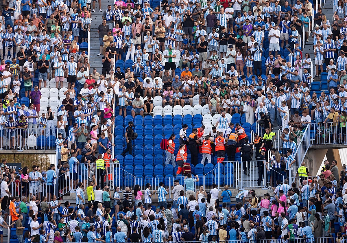 Las asistencias médicas, llevándose en camilla al aficionado afectado.