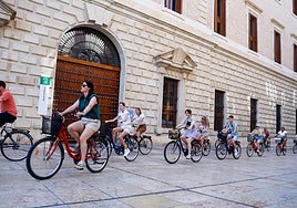 Turistas recorren el Centro de la ciudad en bicicleta.