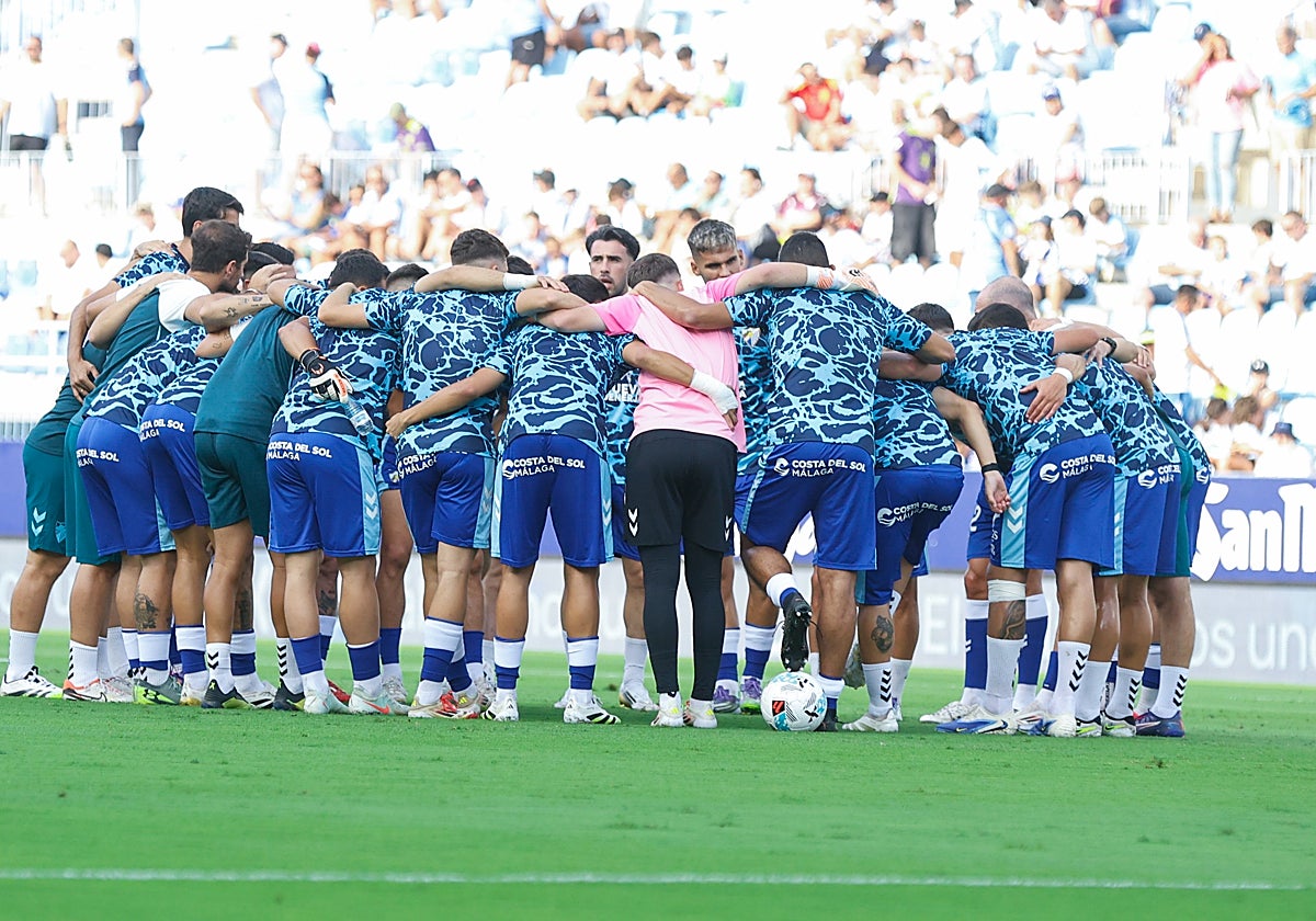 La 'piña' de los jugadores malaguistas, titulares y suplentes, antes del debut liguero ante el Eibar en La Rosaleda el sábado.