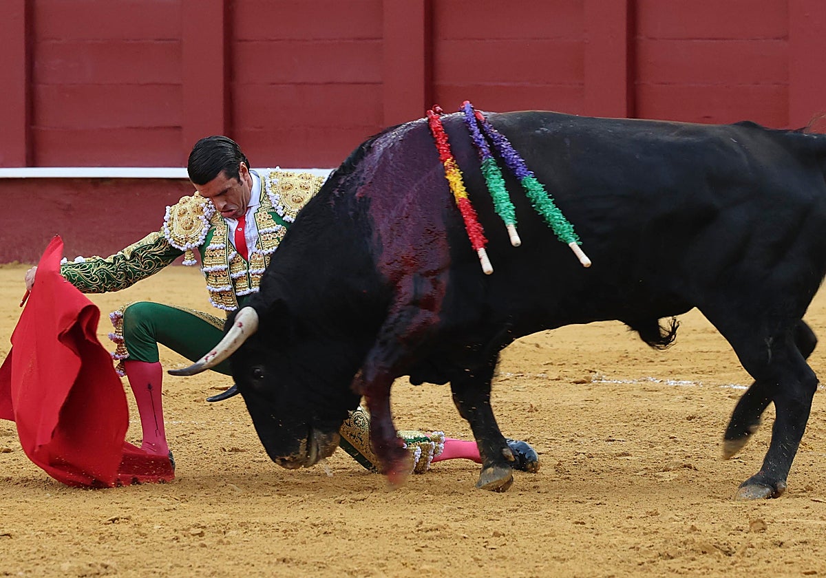 Emilio de Justo iniciando la faena al tercero de la tarde por bajo con una rodilla en tierra.