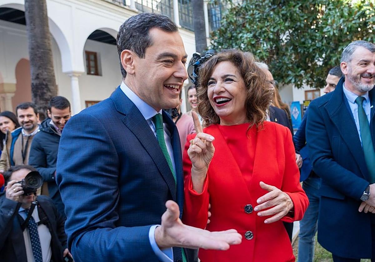 Juanma Moreno y María Jesús Montero sonríen en un acto en el Parlamento andaluz.