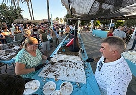 Colas para recoger su porción de tarta gigante gratuita, este jueves en el paseo marítimo de Torre del Mar.