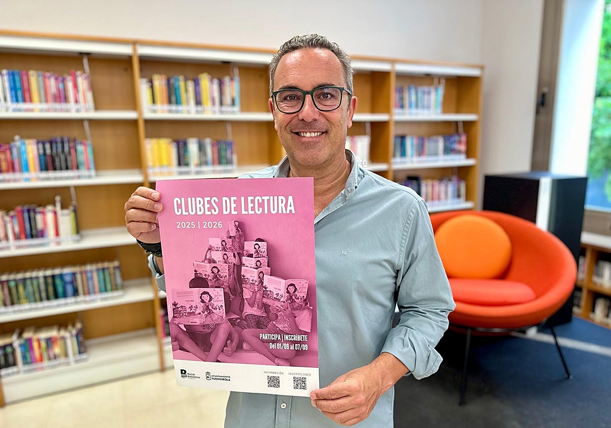 El concejal de Cultura, Rodrigo Romero, posa con un cartel promocional de los clubes de lectura.