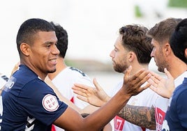 El saludo inicial entre los dos equipos, La Unión Atlético (de azul marino) y el Antoniano (blanco), con las dos equipaciones del club sevillano.