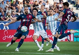 Dotor pugna con Pulido e Íñigo Peña, en el Huesca-Málaga del sábado.