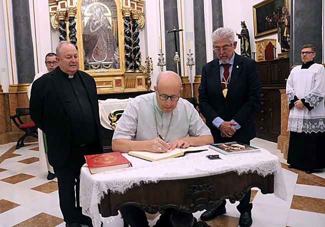 Monseñor Satué, firmando en el libro de la parroquia de los Mártires.