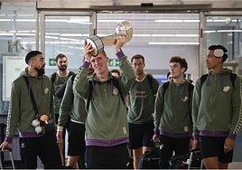 Alberto Díaz, con el trofeo, y el resto de jugadores a su llegada a Málaga.