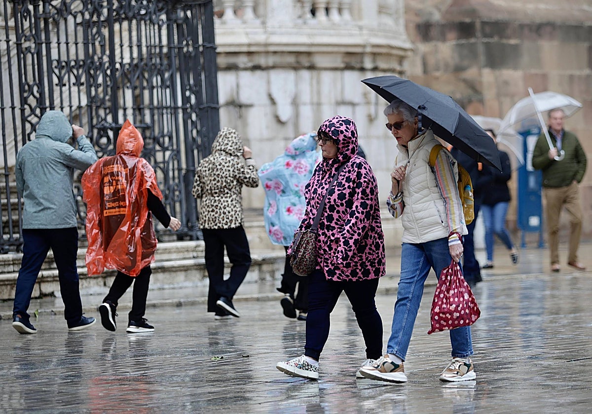 Turistas bajo la lluvia en el Centro de Málaga, en una imagen de archivo.